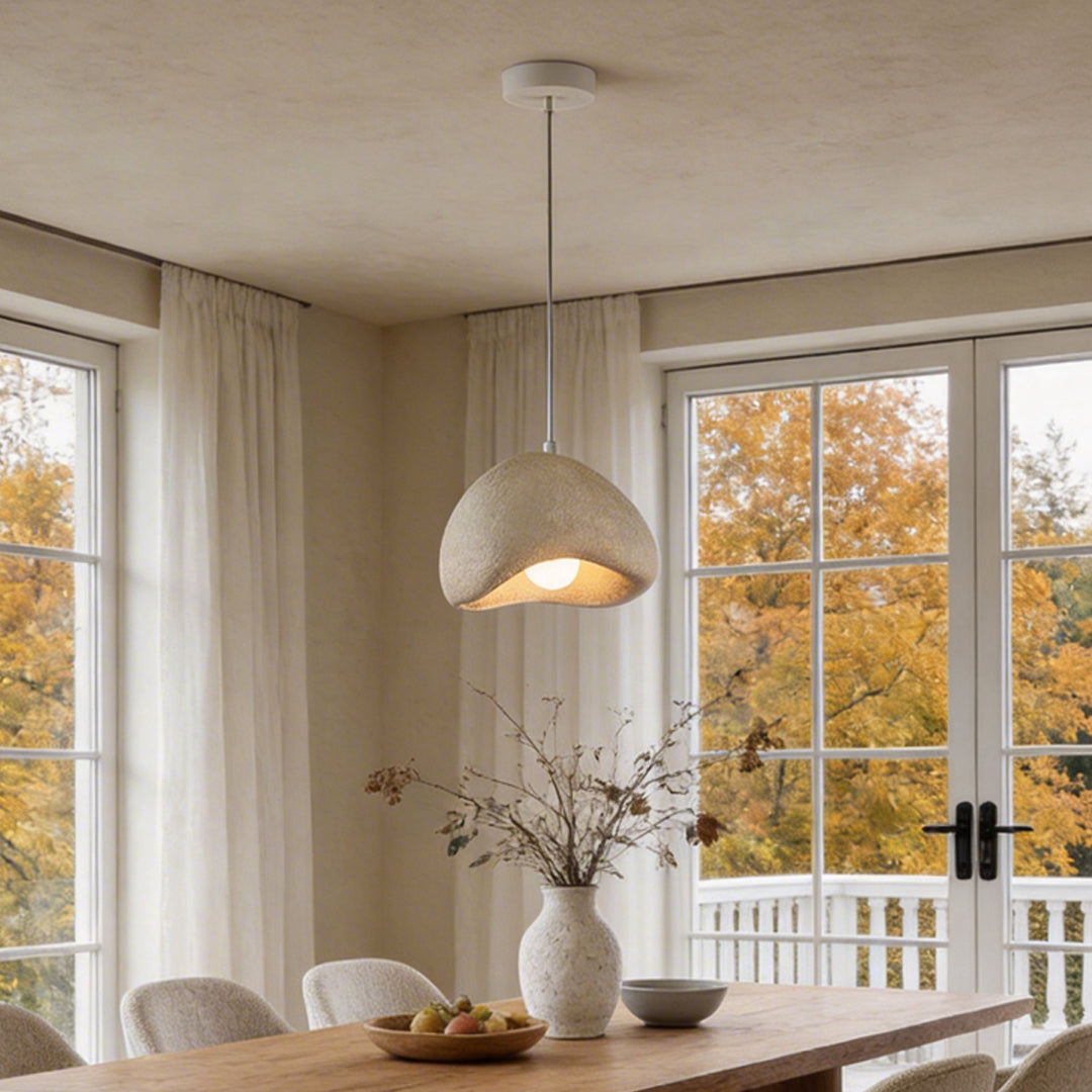 Modern dining area featuring a stylish resin pendant light with a textured surface and warm glow.