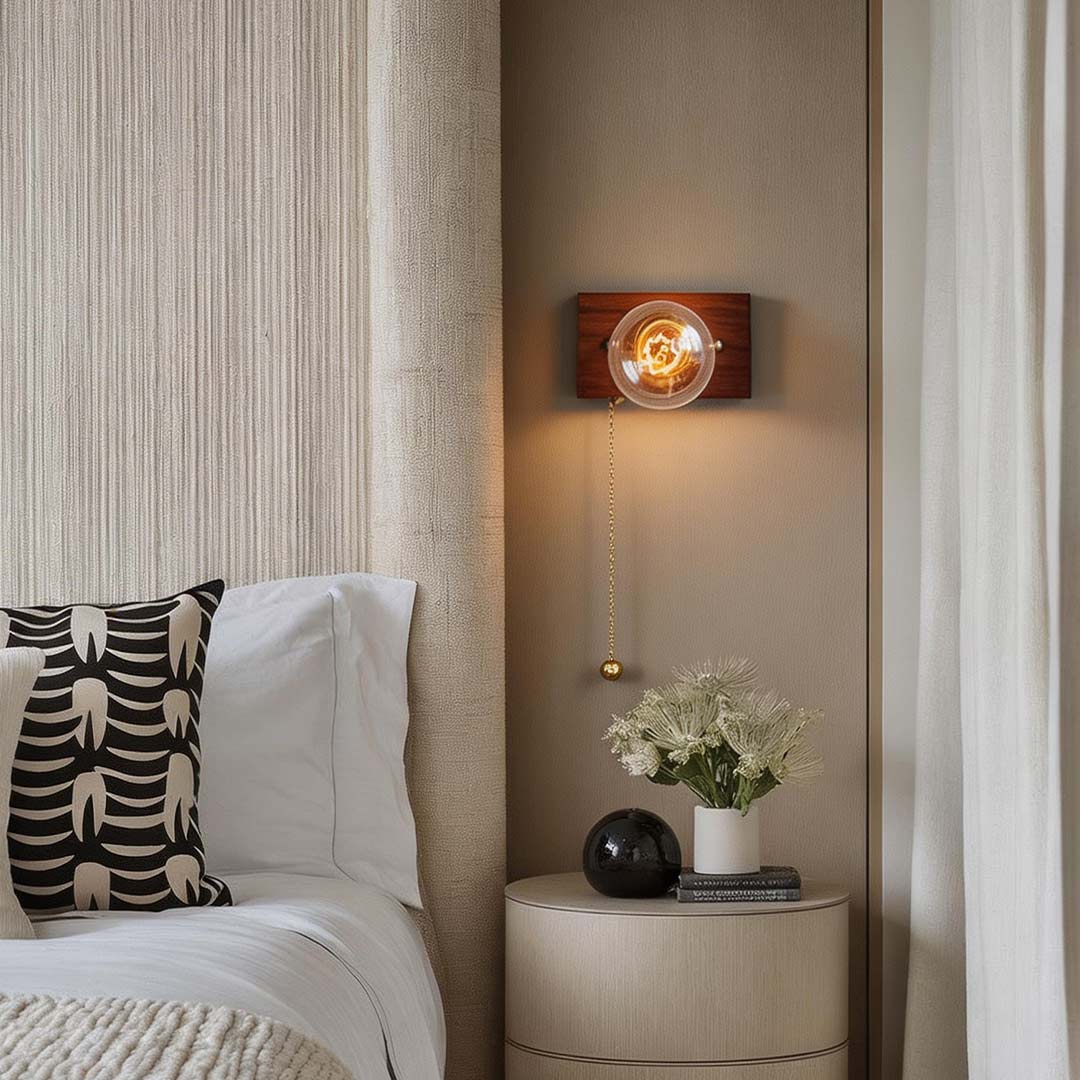 Retro bedside wall light with a pull-chain switch, enhancing a cozy bedroom corner.