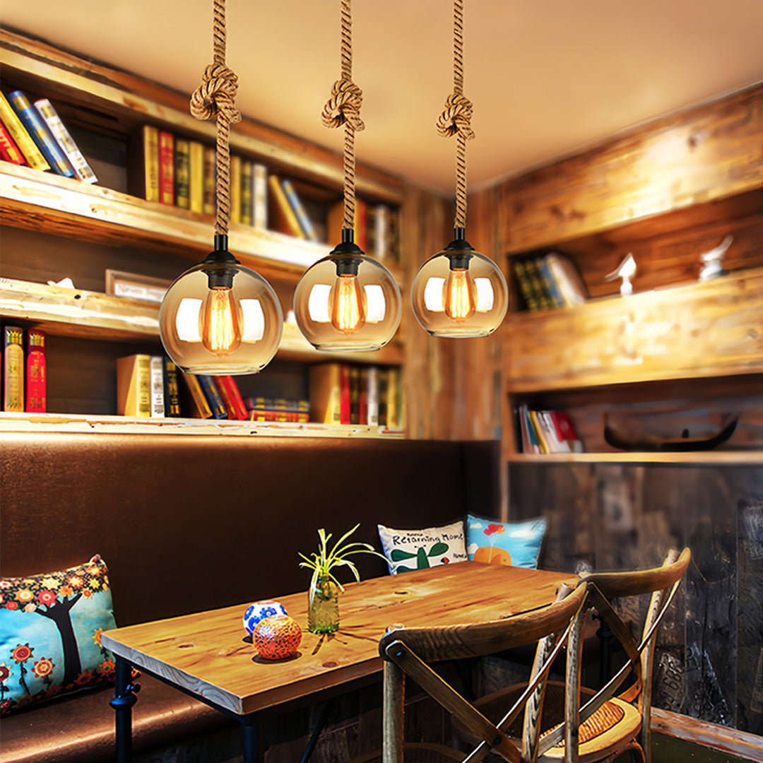 Multiple retro glass pendant lights creating atmospheric lighting in trendy cafe environment.