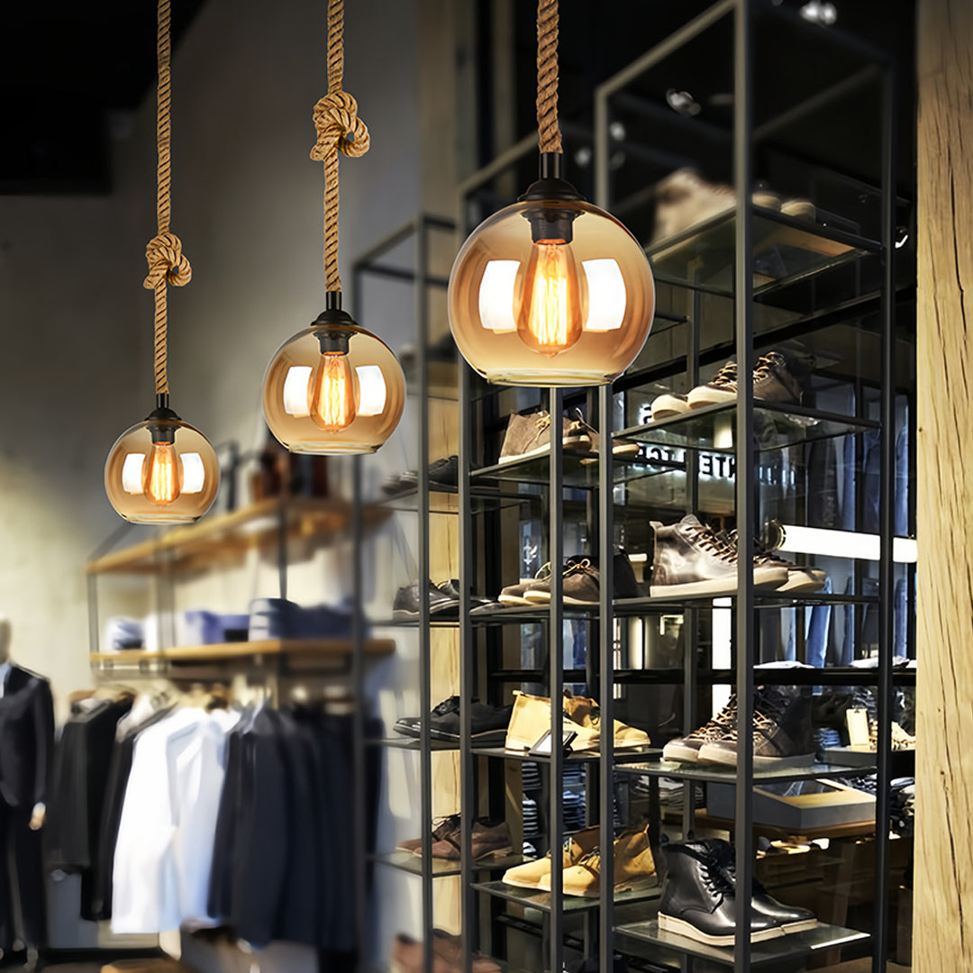 Retro glass pendant lights enhancing modern retail space with warm industrial ambiance.