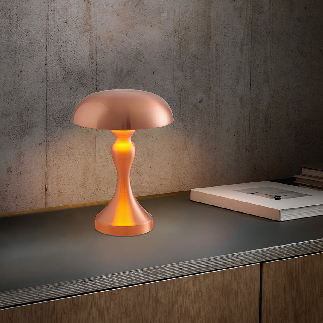 Retro metal table lamp with coral shade casting atmospheric glow on textured concrete surface