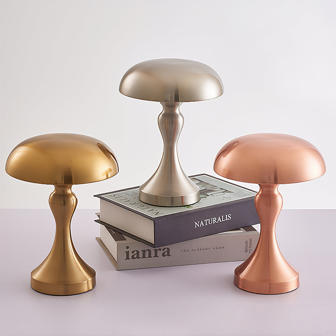 Pair of retro metal table lamps in coordinating finishes beside decorative books