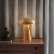Retro metal table lamp illuminating wooden console with warm ambient lighting at dusk