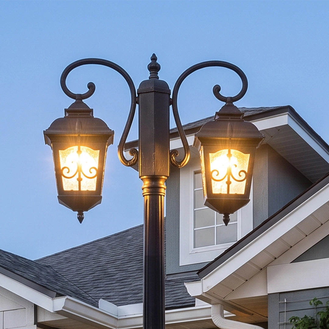 Retro outdoor lamp post with two ornate lanterns, shown in a close-up view with decorative scroll arms and warm vintage illumination.