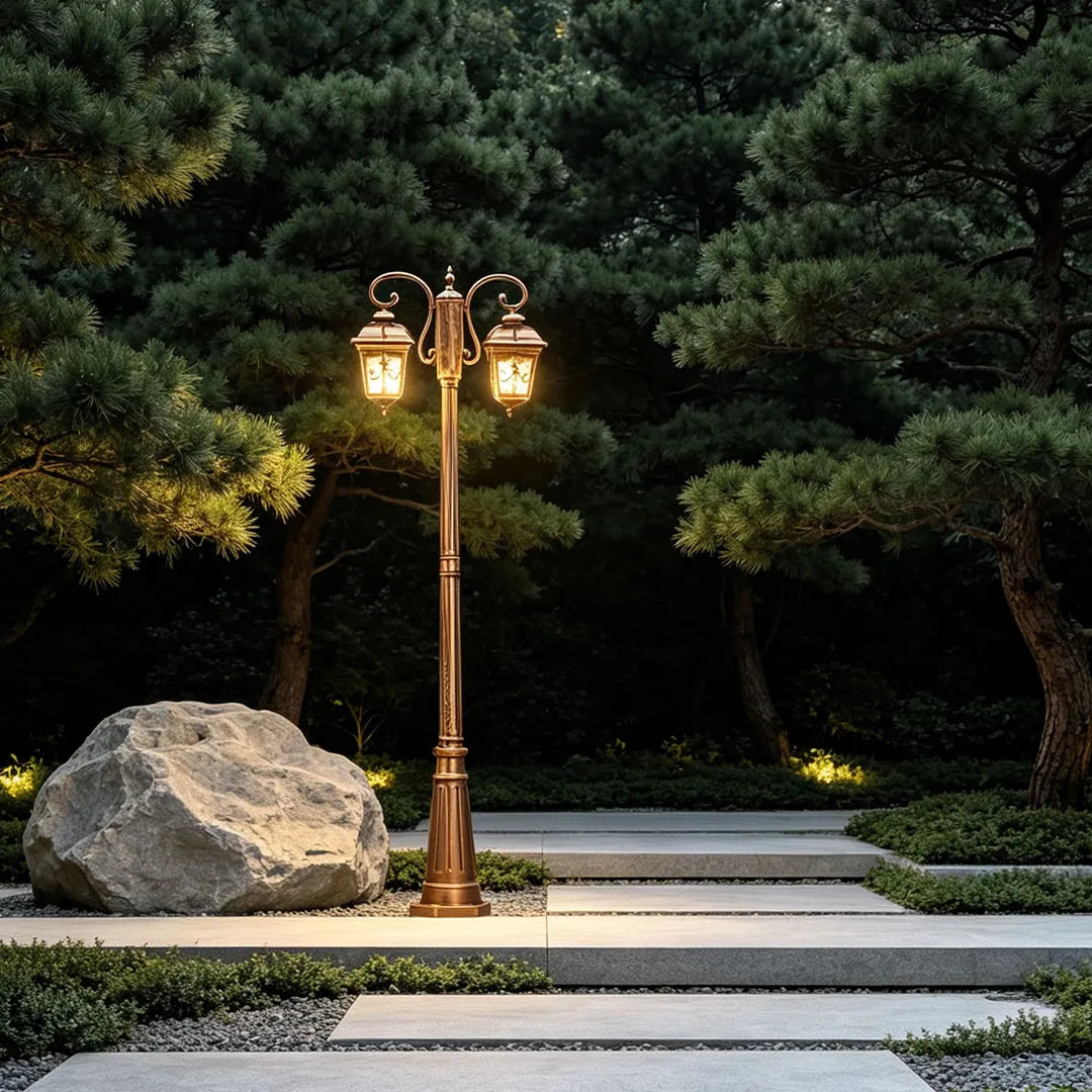 Retro outdoor lamp post placed beside stone steps and landscaping, featuring a classic twin-lantern design.