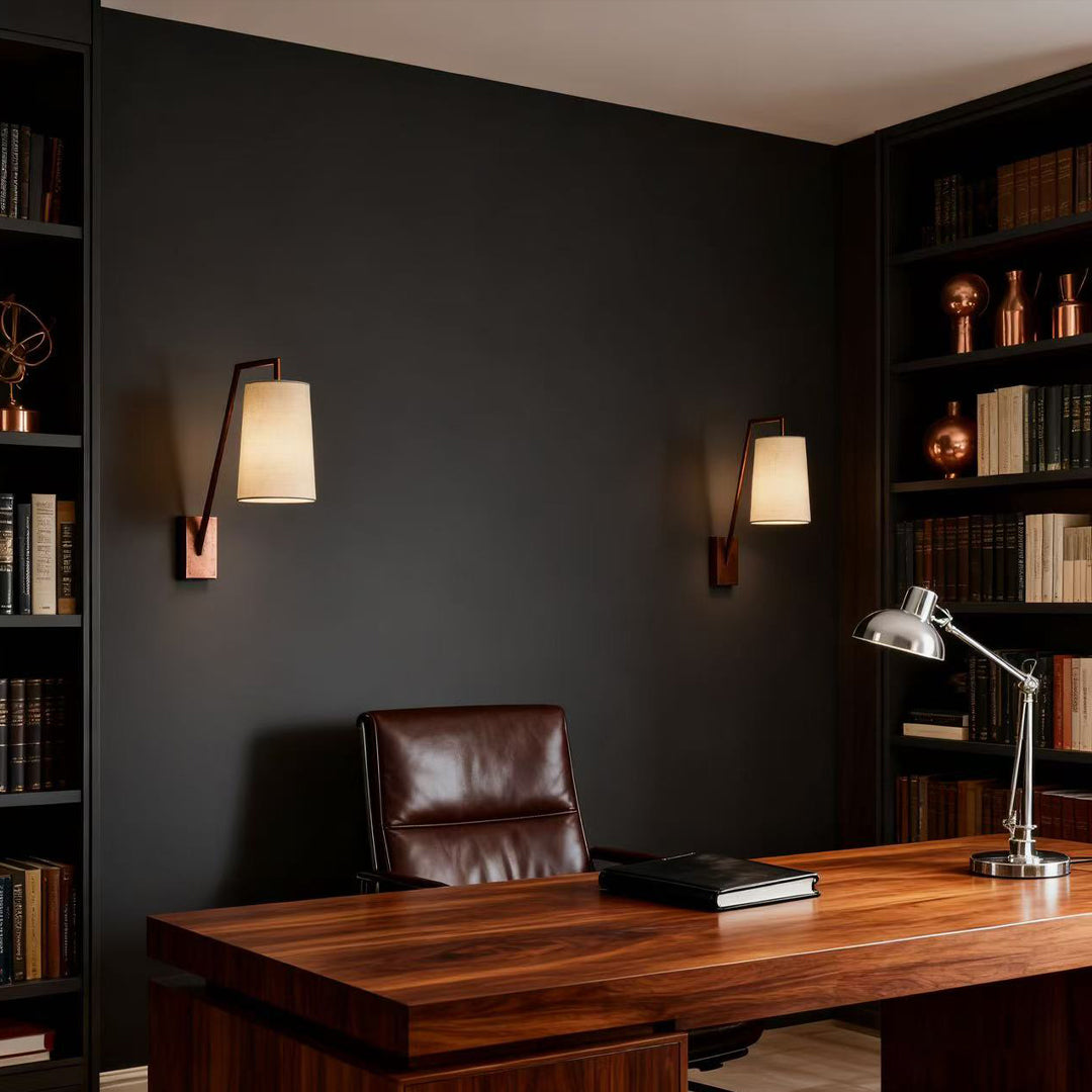 Retro wall lights flanking dark accent wall in modern office with wooden desk and leather seating