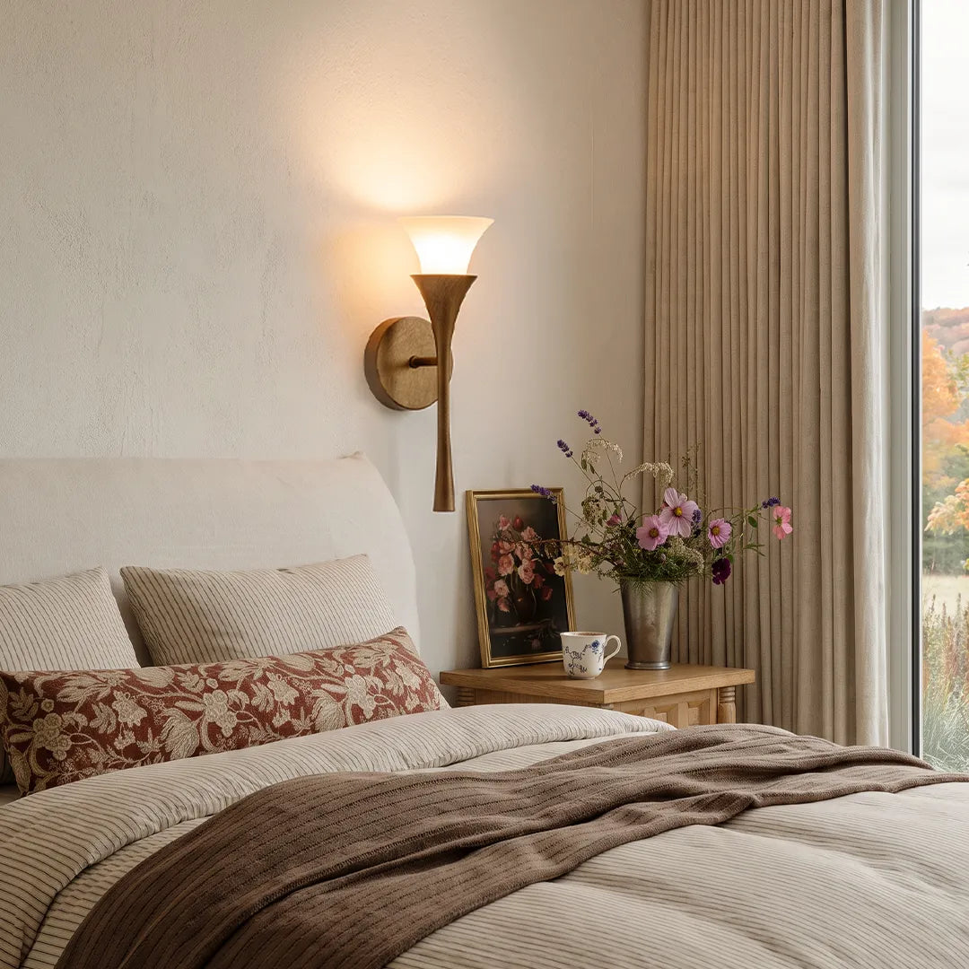 Retro wall sconce adding soft accent lighting above a bedside table in a neutral bedroom.