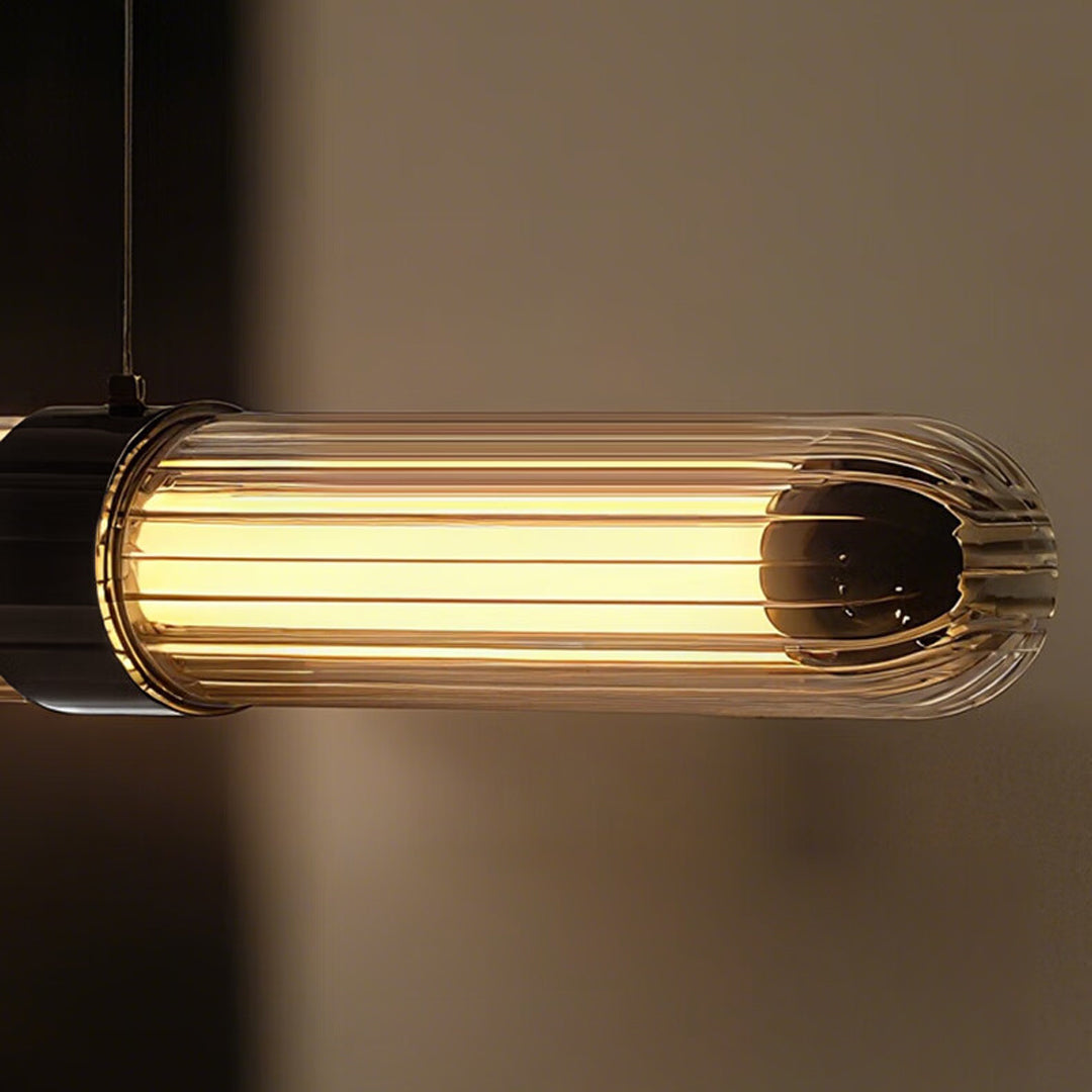 Detailed close-up of a ribbed glass modern linear suspension lighting fixture emitting warm light.