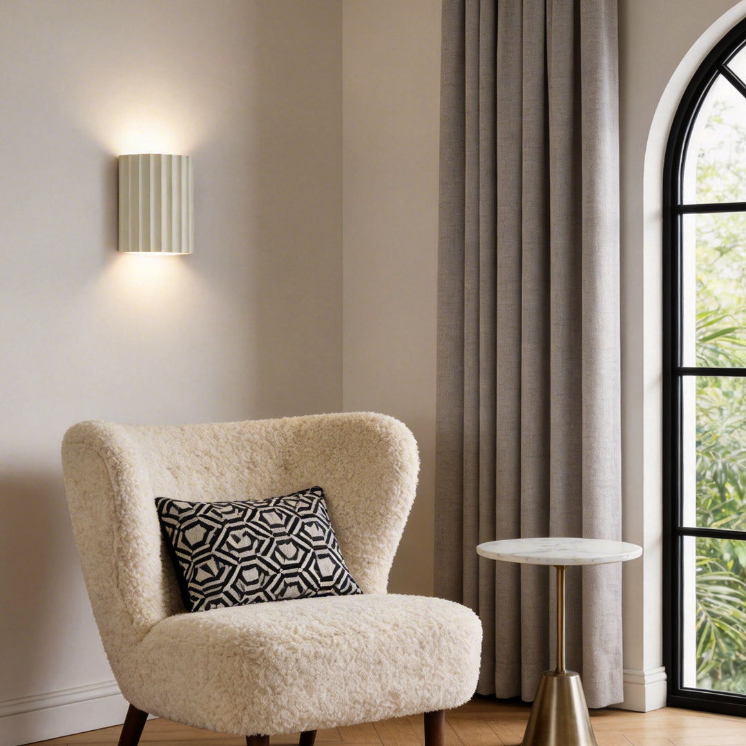 Ribbed wall sconces illuminating a cozy reading corner with warm directional glow.