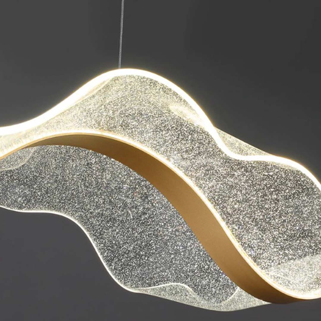 Close-up of ribbon pendant light showcasing its intricate golden wave design.
