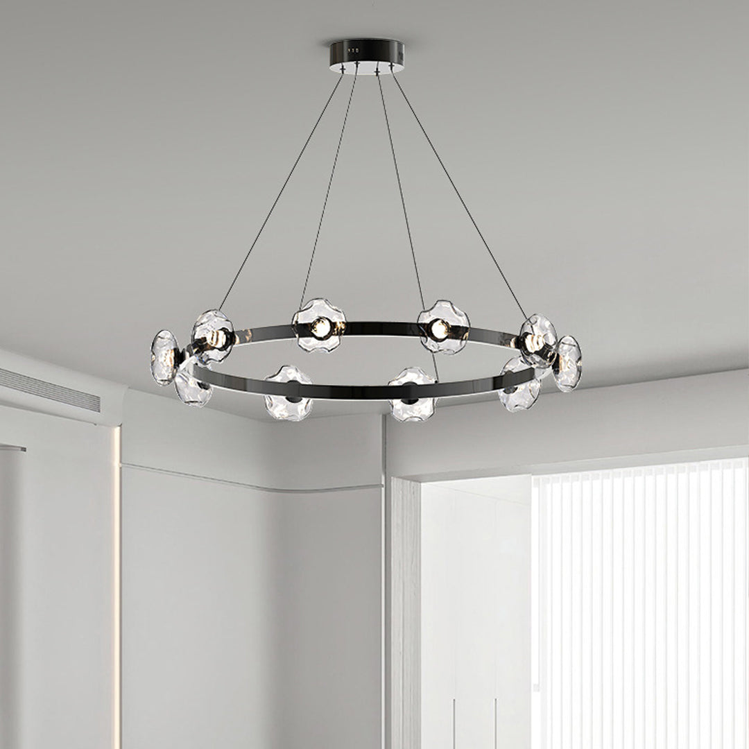 Ring chandelier suspended over minimalist bedroom creating elegant ambient lighting with glass orb details
