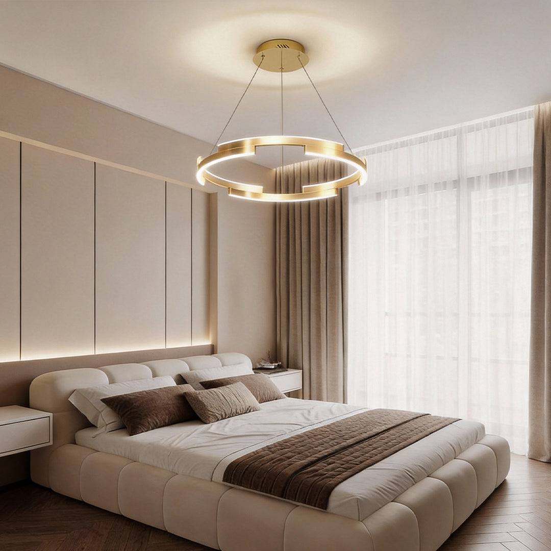 Ring chandelier brass providing soft light above a contemporary bedroom.