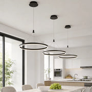Ring metal chandelier with black circular frame hanging above a modern kitchen island in a bright open interior.