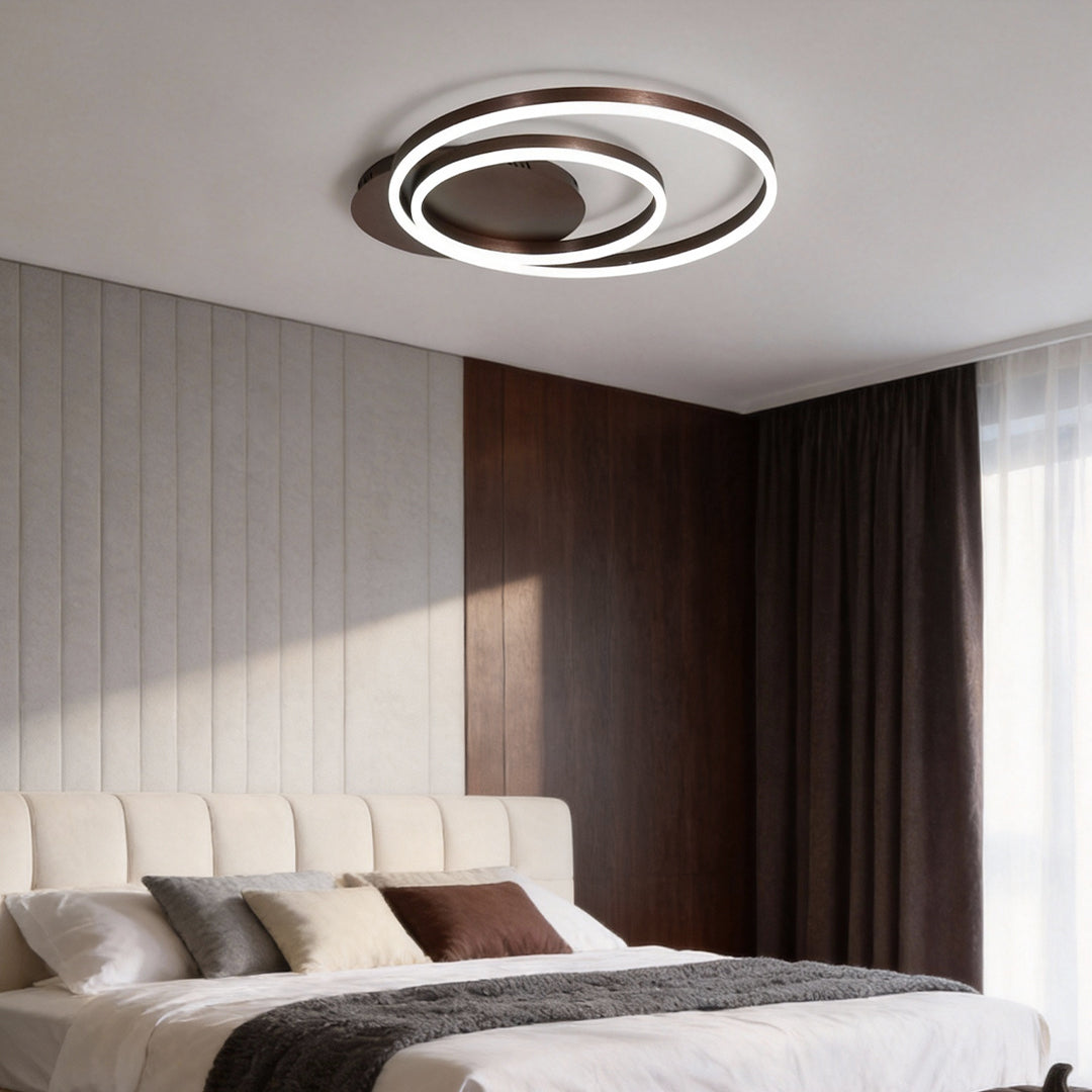 Ring pendant light fixture providing soft light above a contemporary bedroom.