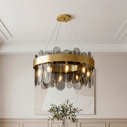 Sophisticated ring-shaped modern traditional chandeliers featuring a wide gold band and sleek smoky glass panels in an elegant room.