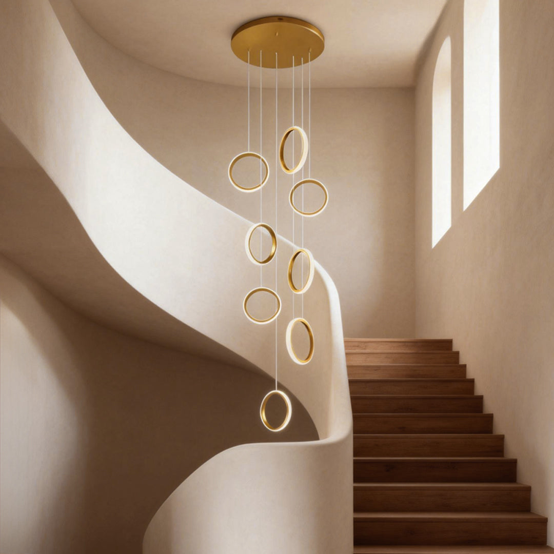 Ring staircase pendant light cascading elegantly down a modern spiral staircase with wooden steps.