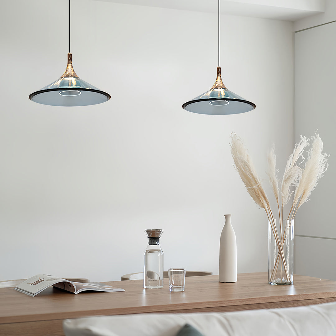 Pair of rise and fall pendant lights with blue shades in airy Scandinavian-style dining room