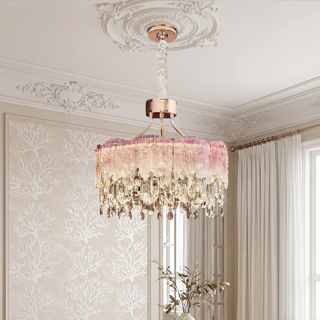 Stunning rose gold glass fringe chandeliers featuring a textured pink glass top tier and cascading clear crystal teardrops suspended in an elegant room.