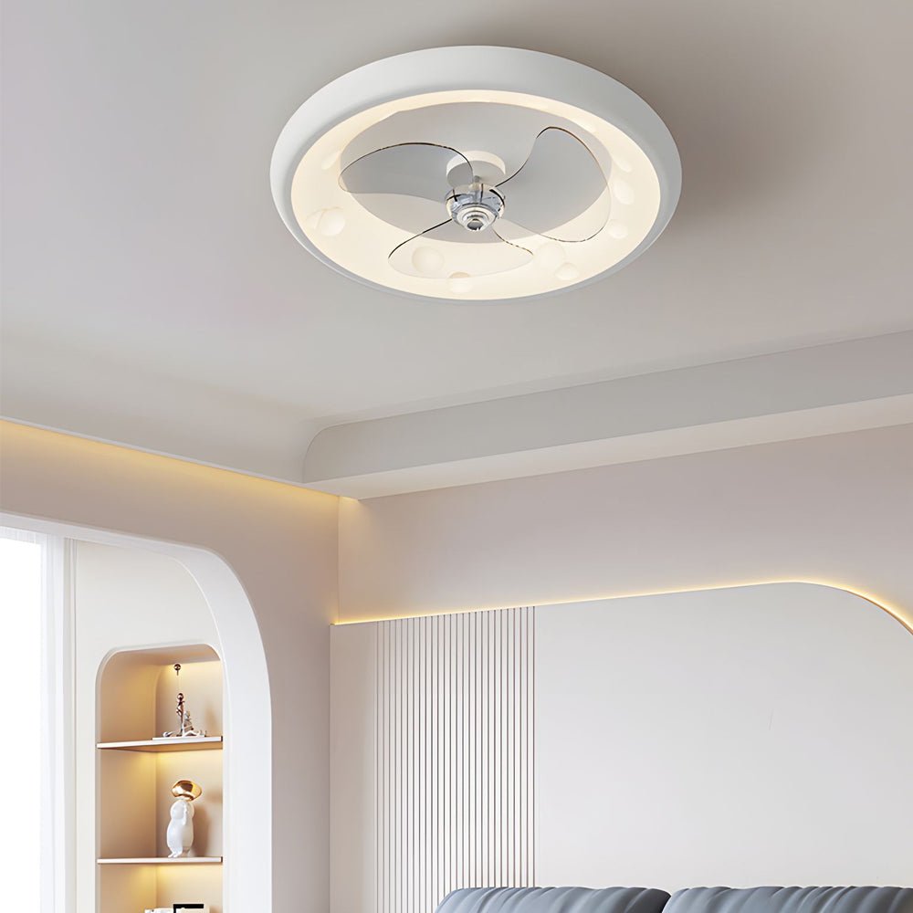 Round ceiling fan with light casting a warm glow in a modern bedroom with a white sofa.