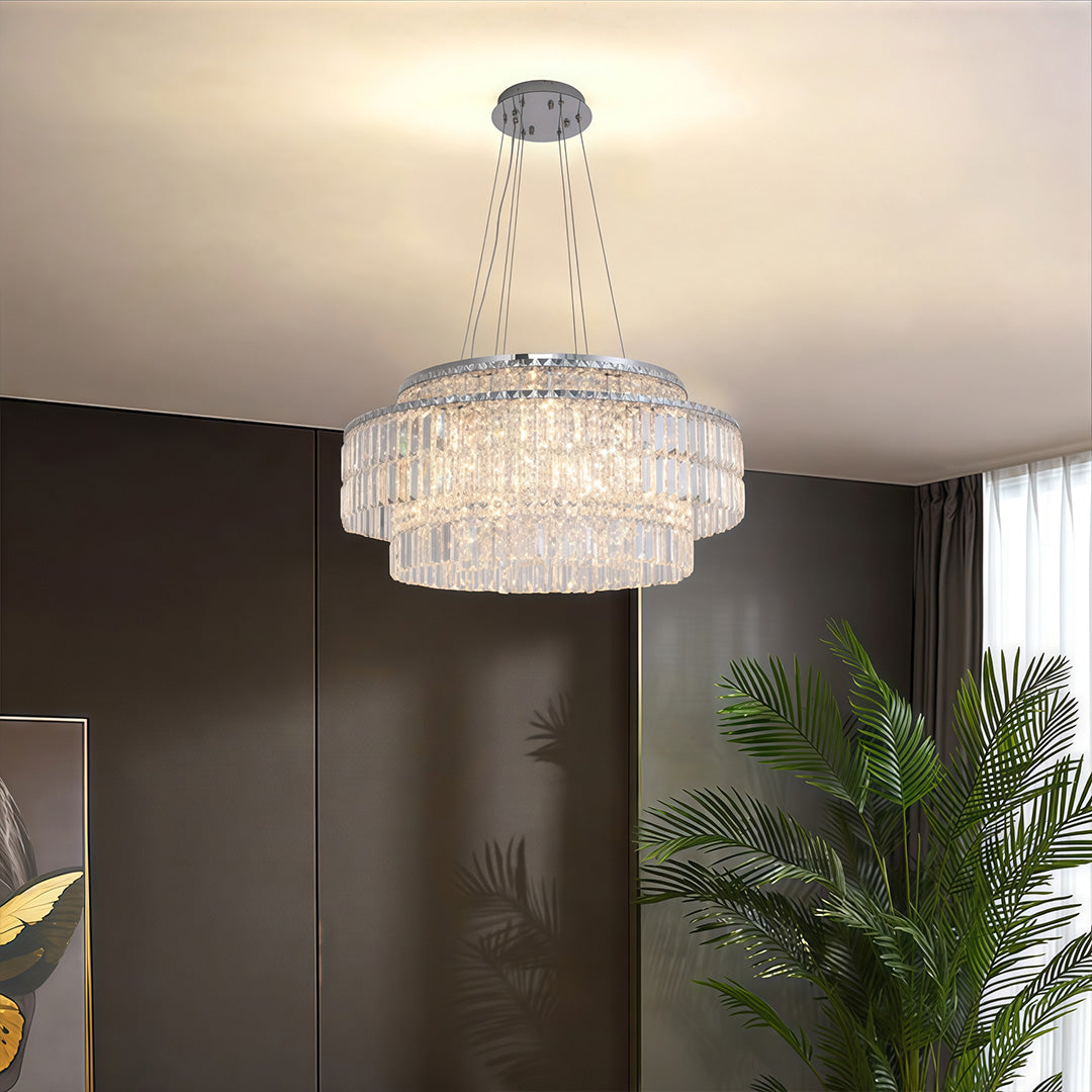 Round chandelier with crystals illuminating modern living room with dark walls and contemporary furniture.