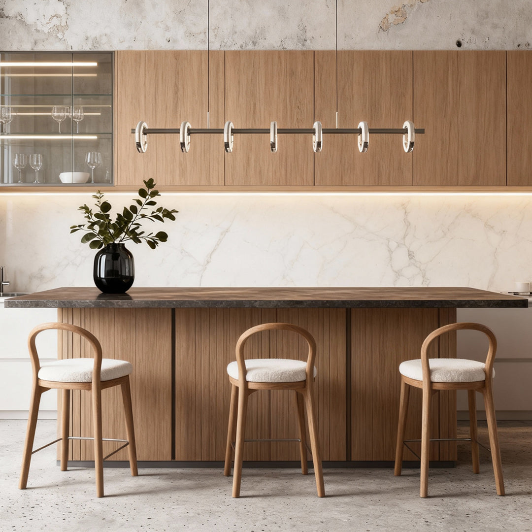 Modern round chandelier installed above a kitchen bar, featuring elegant circular glass ring lights.