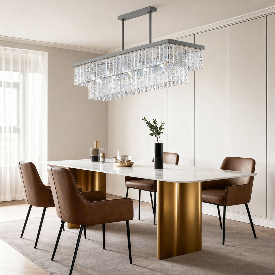 Round modern chandelier creating warm ambiance in dining room with cylindrical gold table