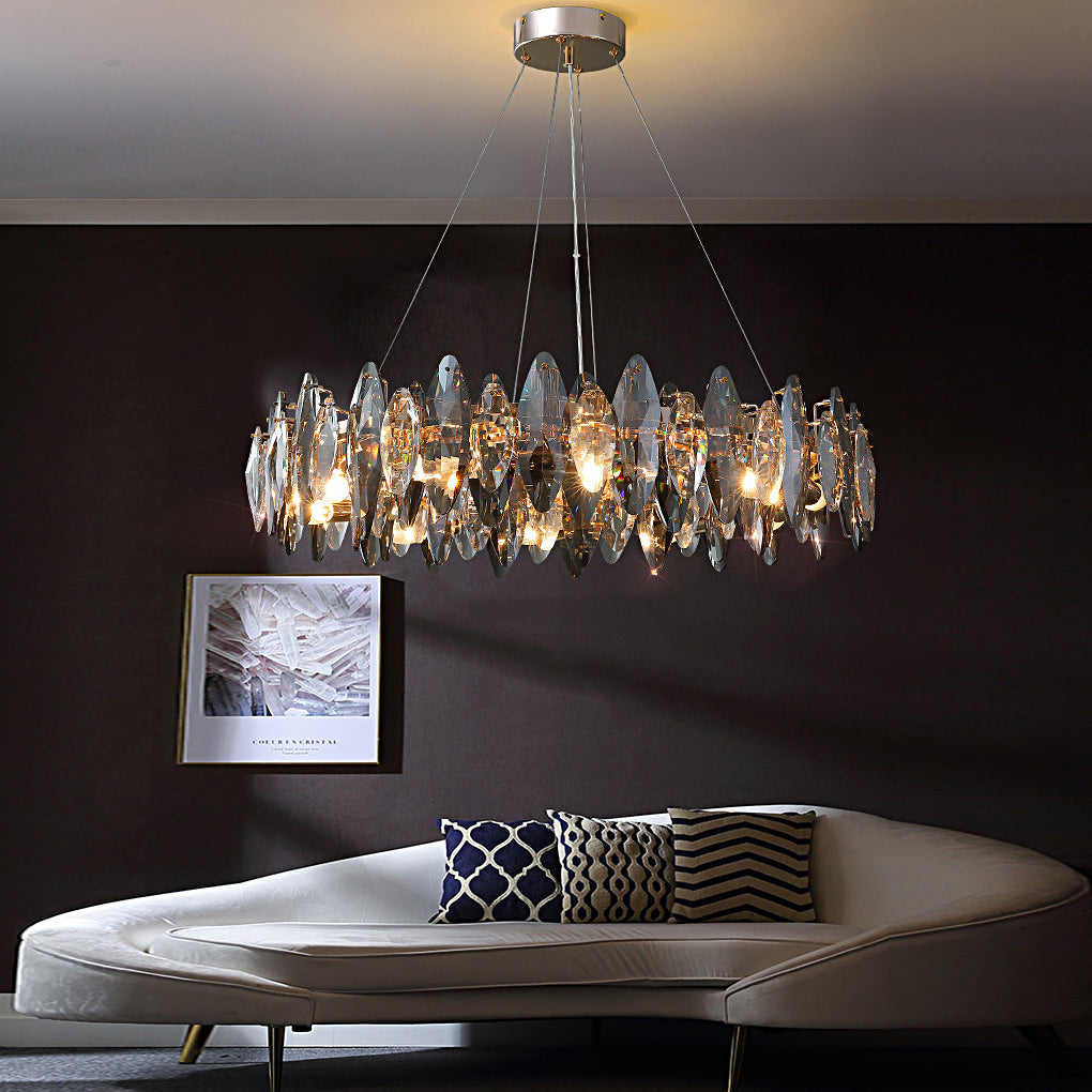 Round chandelier with crystals creating a warm glow in a sophisticated dark-toned interior.