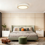 Round crystal ceiling light bringing soft illumination to a stylish bedroom interior.