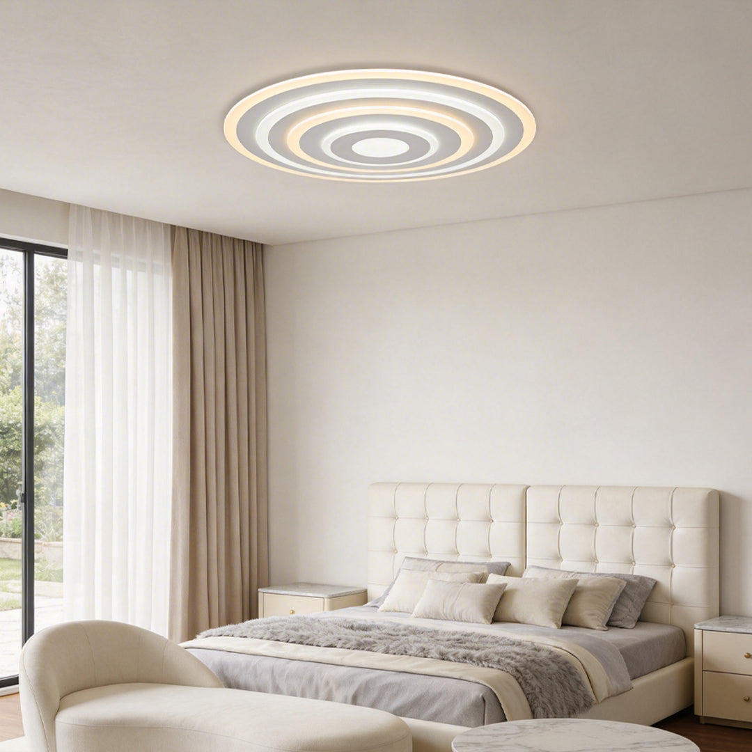 Round flush mount ceiling light with a sleek design, enhancing a contemporary bedroom.
