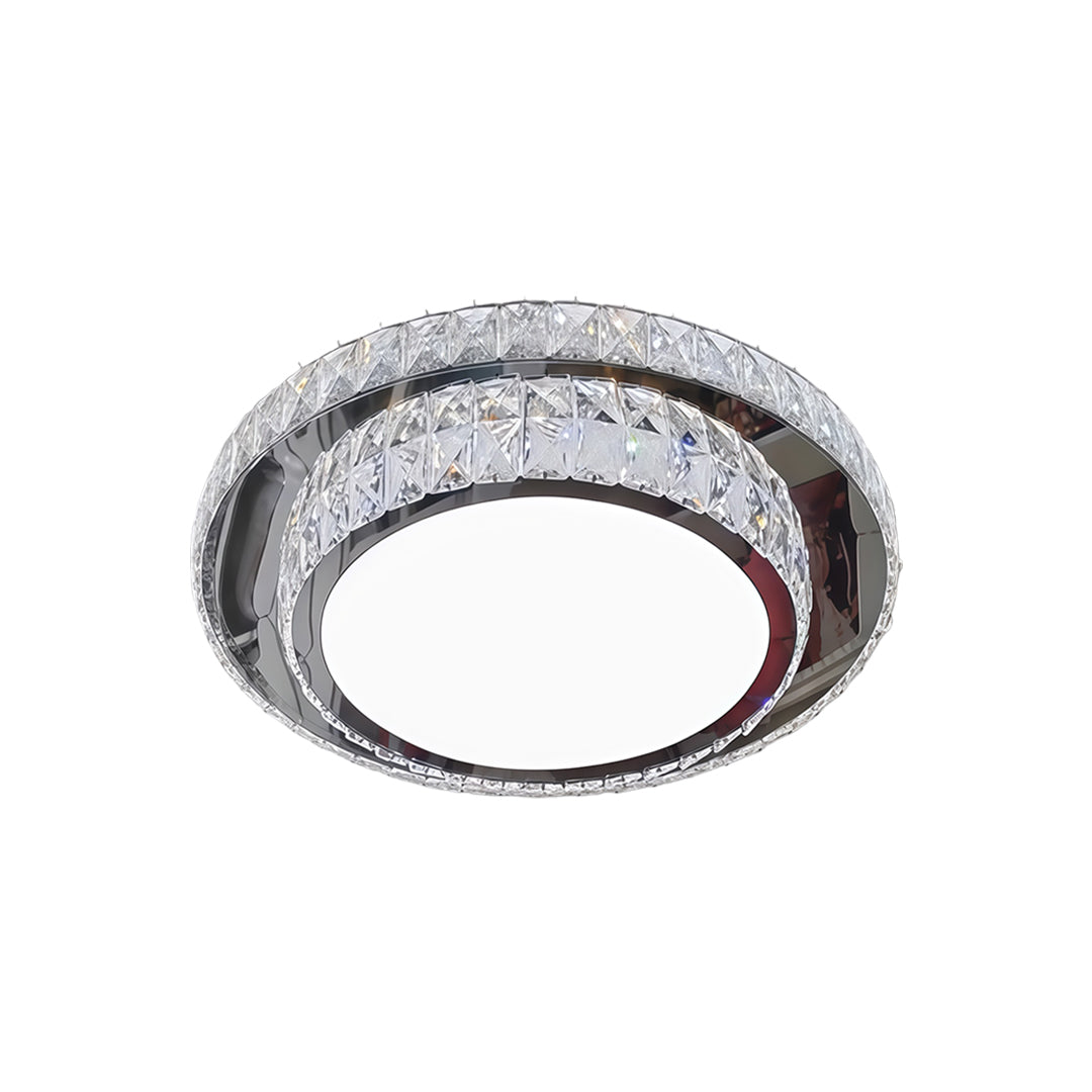 Round flush mount crystal light fixture with glittering crystal trim and sleek silver finish.