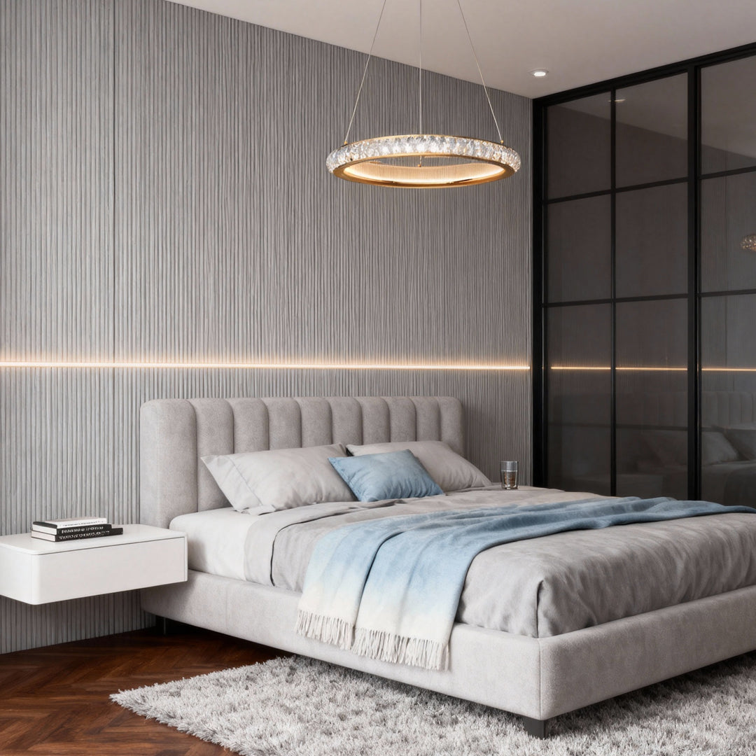 Round gold crystal chandelier illuminating modern bedroom with tufted gray bed and contemporary interior design