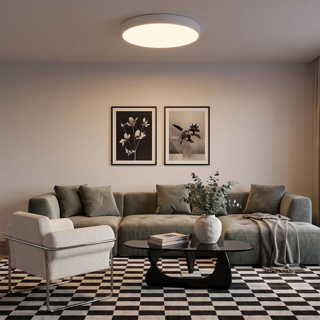 Round LED ceiling lights illuminating a cozy living room with sectional sofa, wall art, and patterned rug.