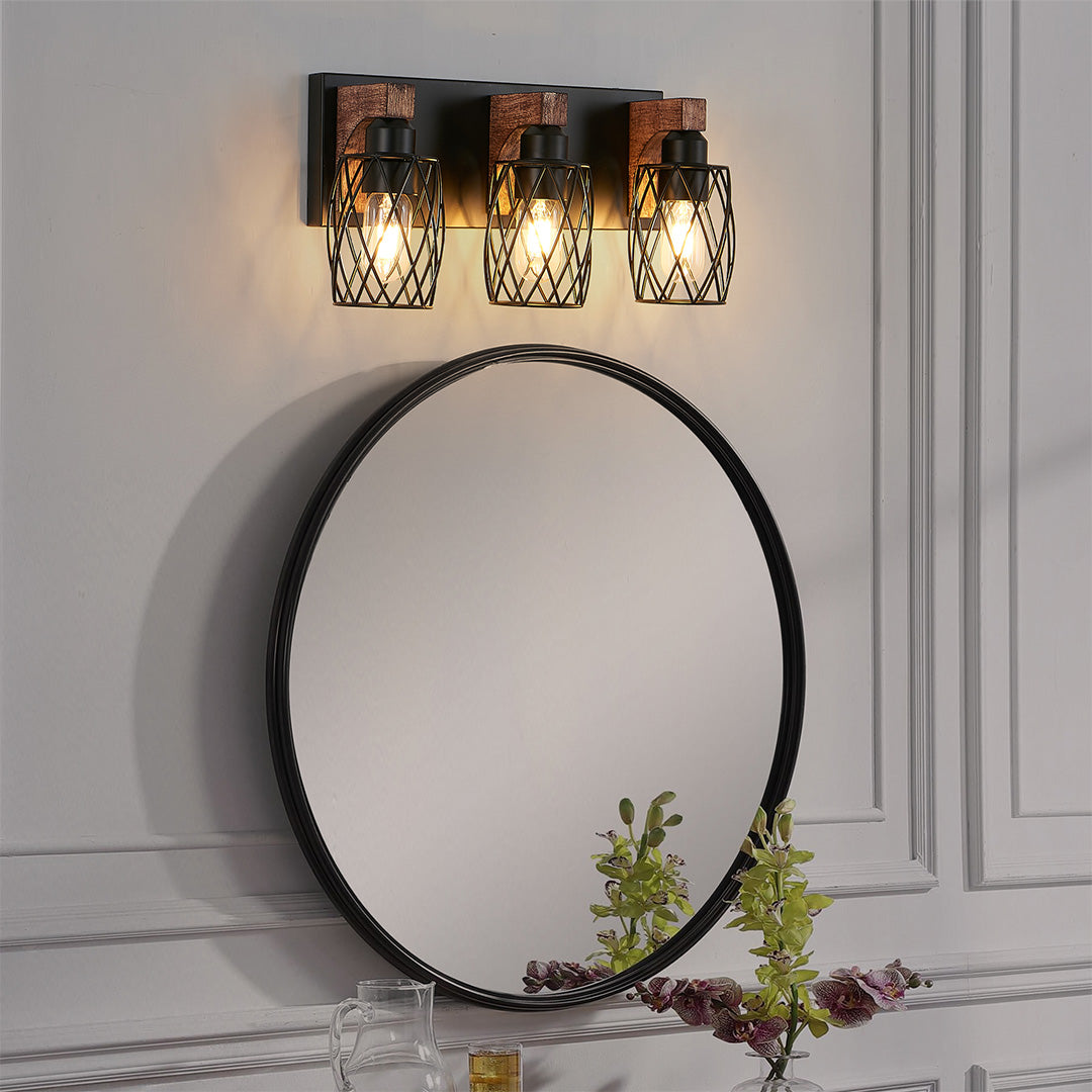 Black vanity bathroom light with three Edison bulbs, mounted above a round mirror in a modern bathroom.