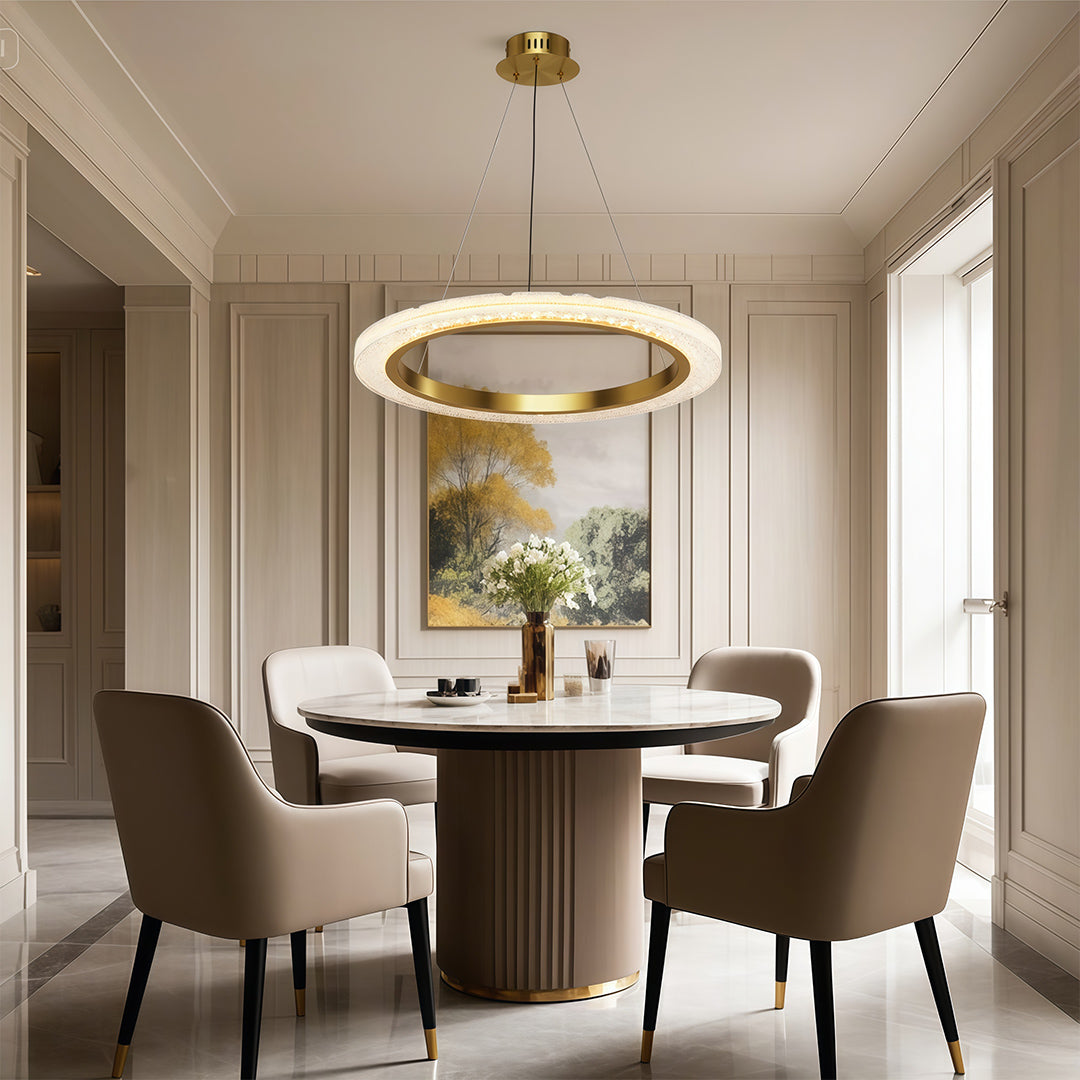 Round modern chandelier above elegant dining table with fluted base and beige chairs
