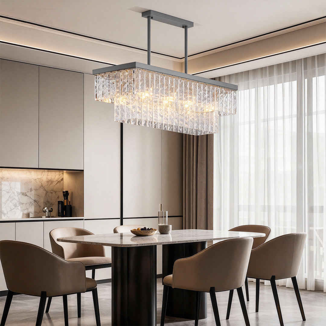 Round modern forms chandelier illuminating contemporary dining room with dark chairs and neutral palette.