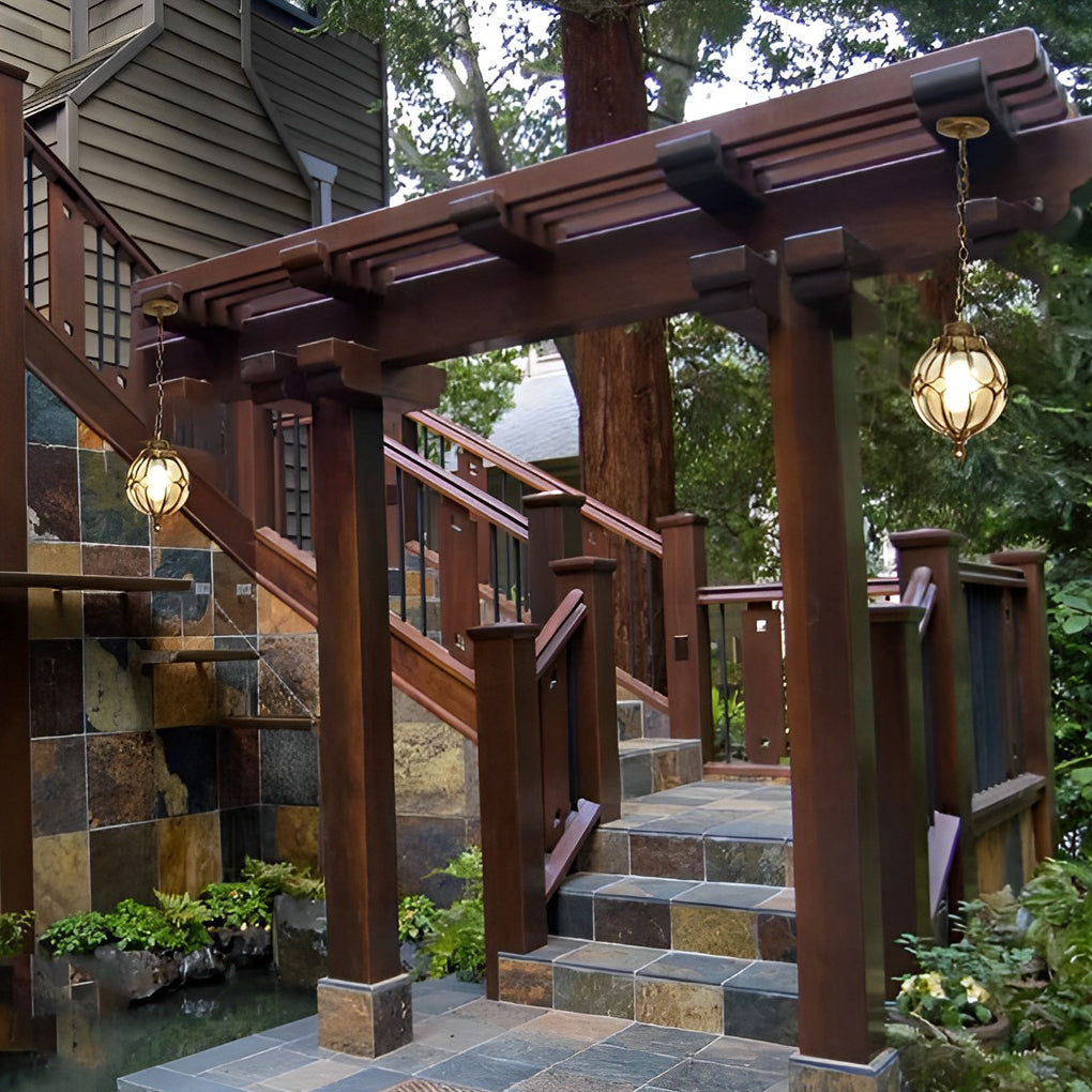 Round outdoor hanging lights with a modern design, illuminating a patio seating area.