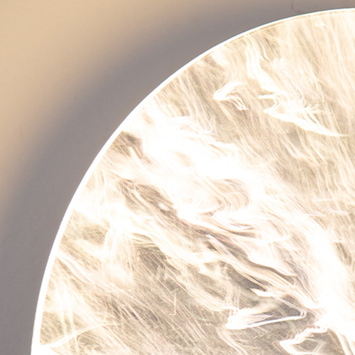 Round outdoor sconce with a close-up of its illuminated texture and design.