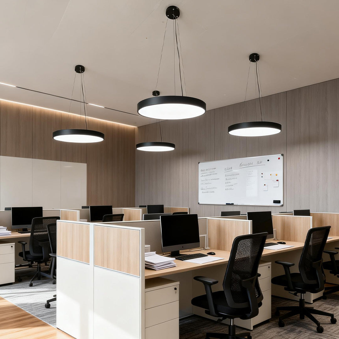 Collaborative workspace illuminated by multiple round pendant lights hanging at uniform heights.