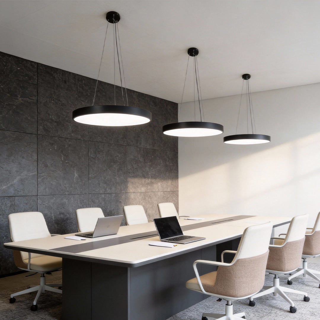 Conference room featuring minimalist round pendant lights suspended above a long meeting table.