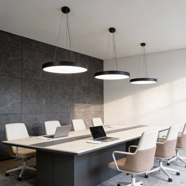 Conference room featuring minimalist round pendant lights suspended above a long meeting table.
