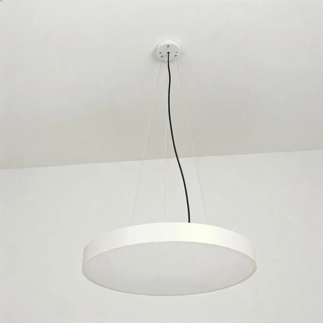 Round pendant lights with a slim white circular frame hanging from a white ceiling.