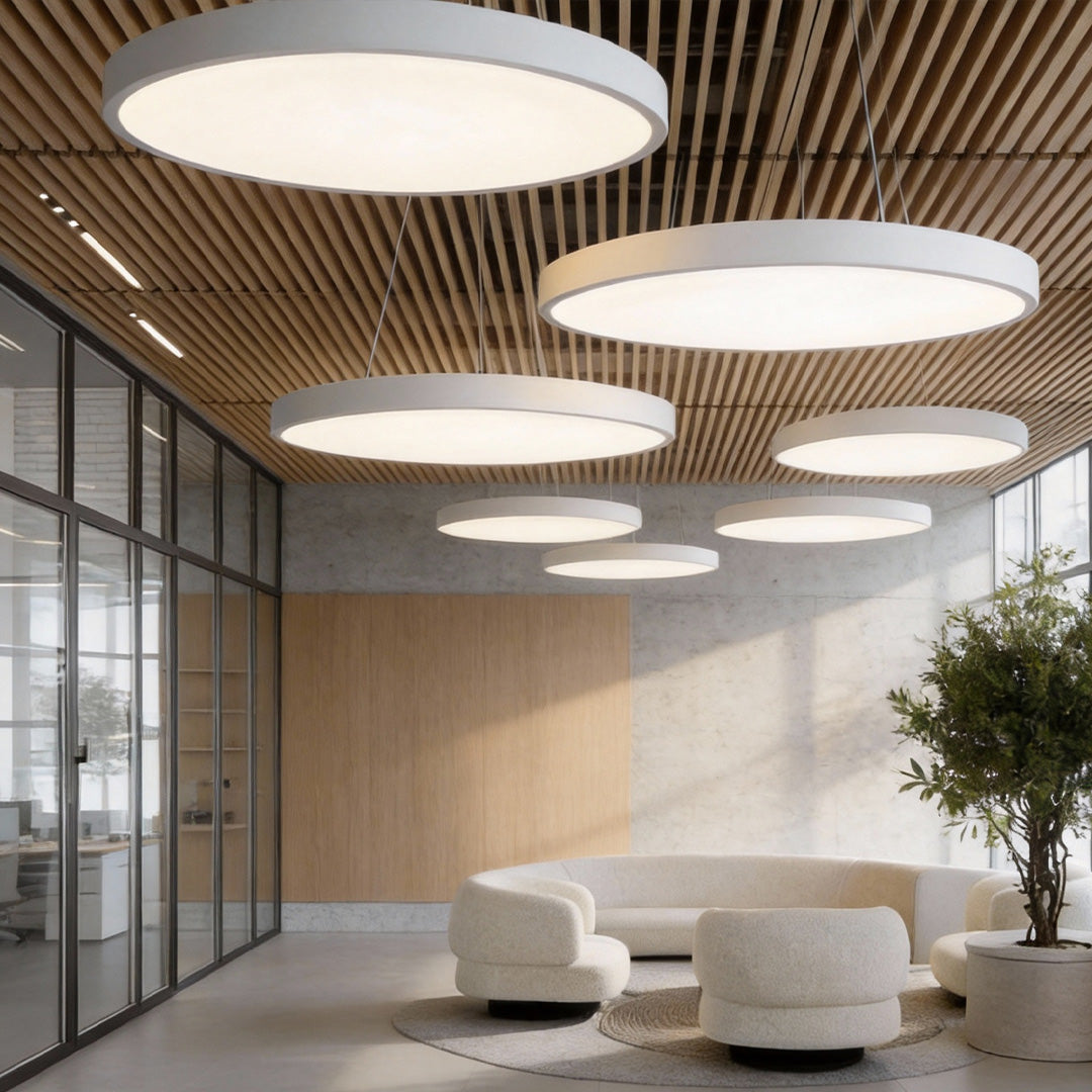 Modern lobby seating area featuring layered round pendant lights across a slatted ceiling.
