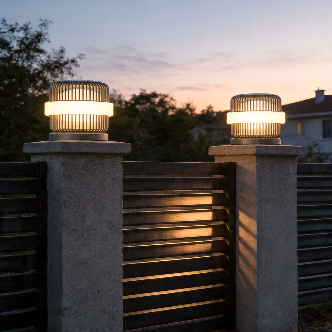 Round pillar lights outdoor mounted on stone gate pillars creating stylish outdoor pathway lighting.