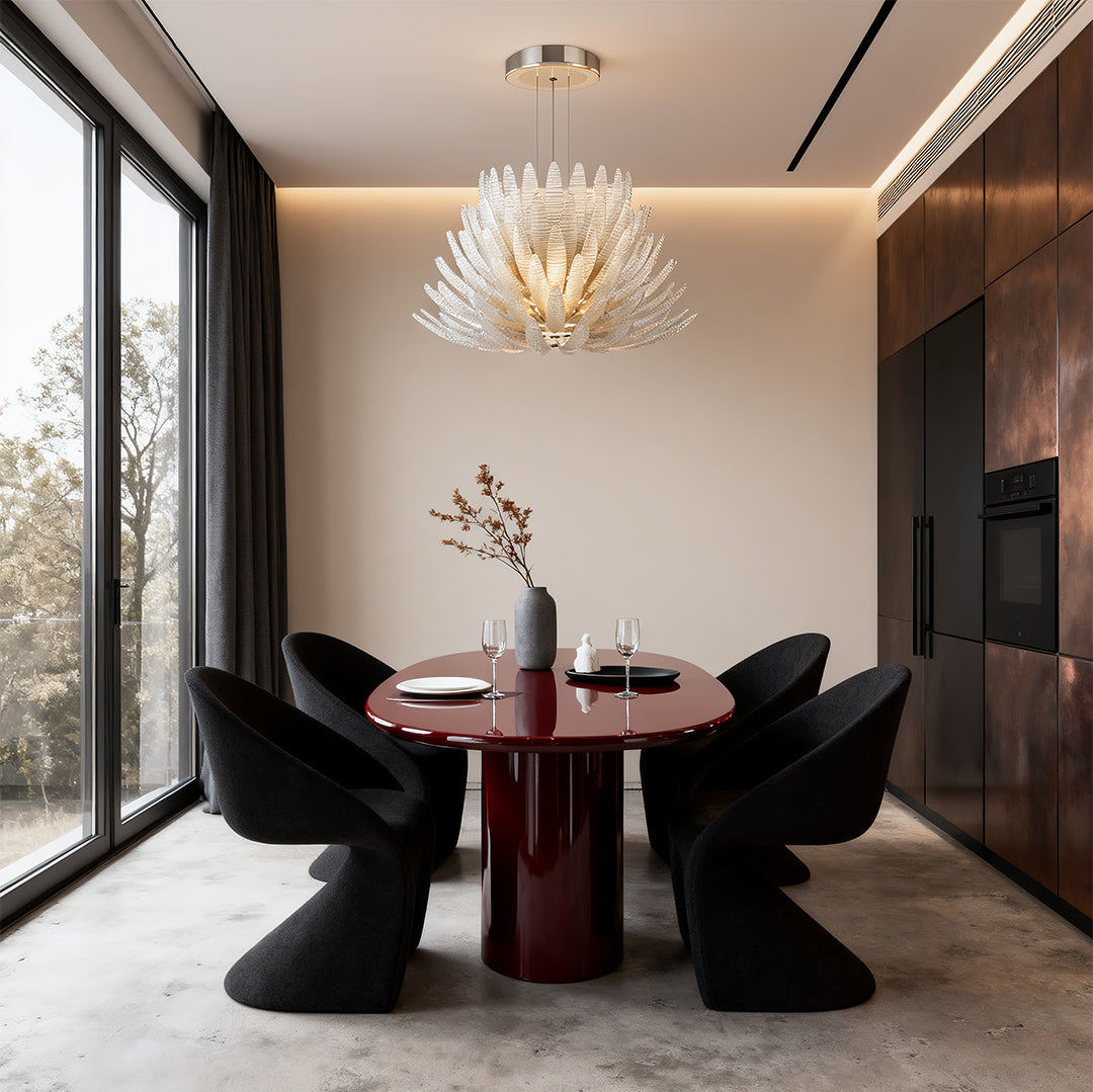 Round dining table under modern deco chandelier with warm glow.