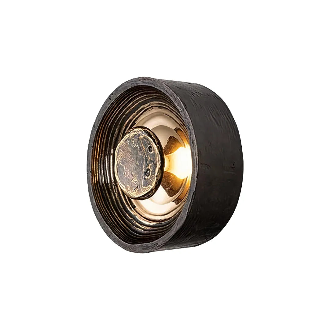 Round wall sconce product image showing a dark circular layered frame with a warm glowing center.