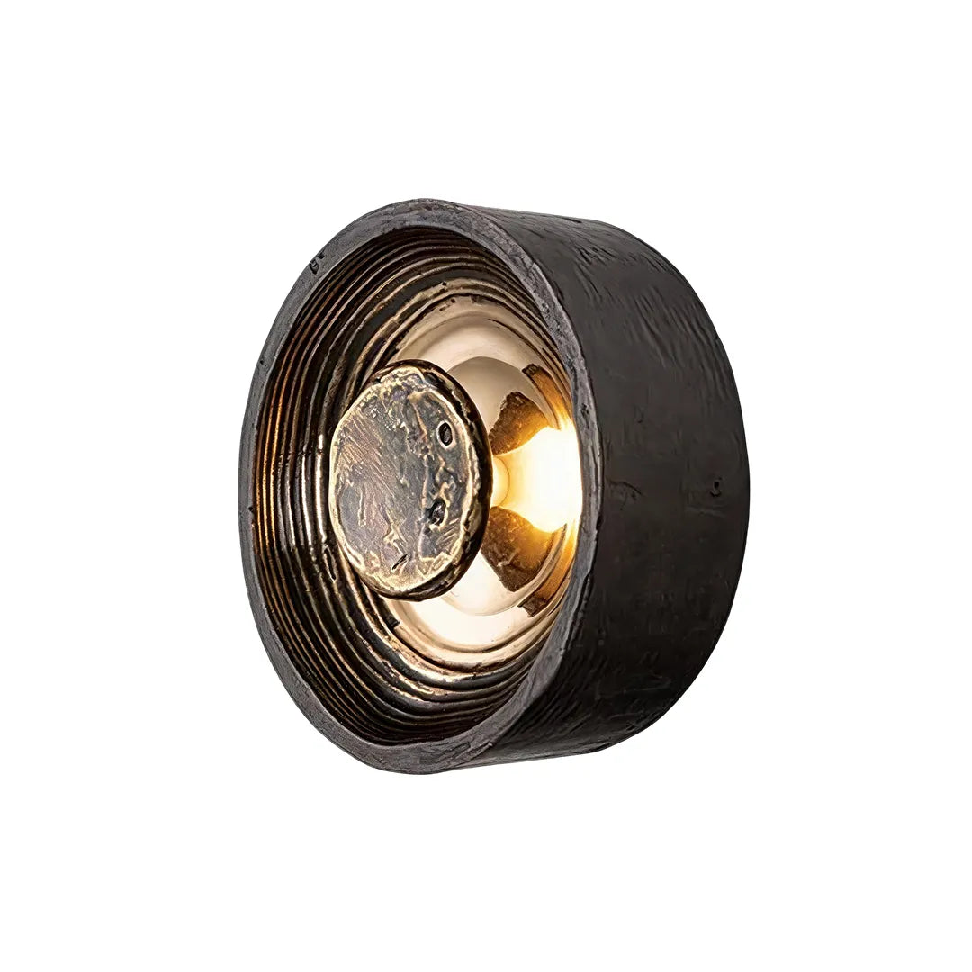 Round wall sconce product image featuring a textured circular design with a warm illuminated center.