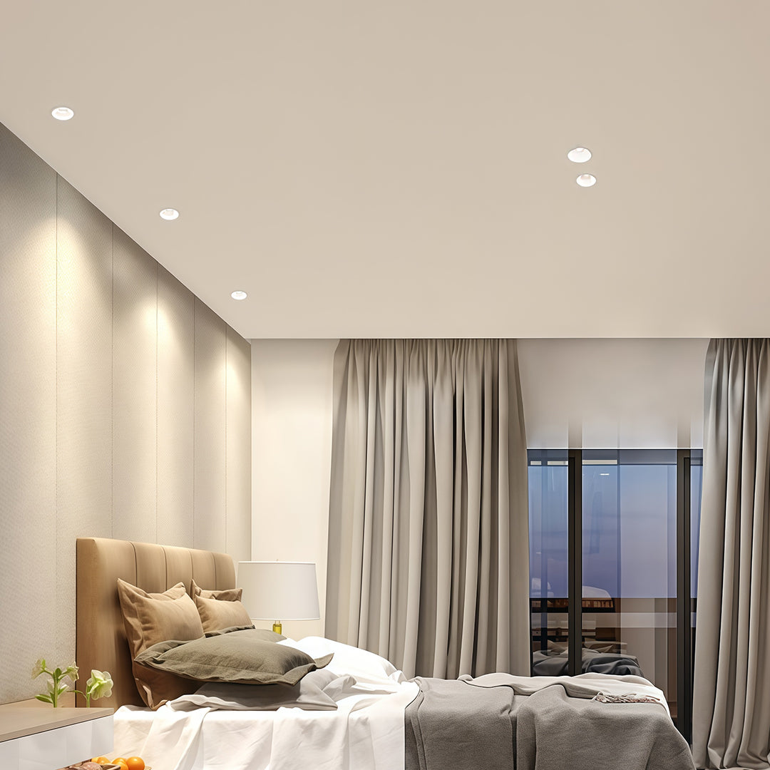 Row of adjustable downlights providing ambient lighting in beige living room with curtains and lounge chair