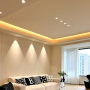 Row of anti glare downlights providing ambient lighting in contemporary bedroom with cove ceiling