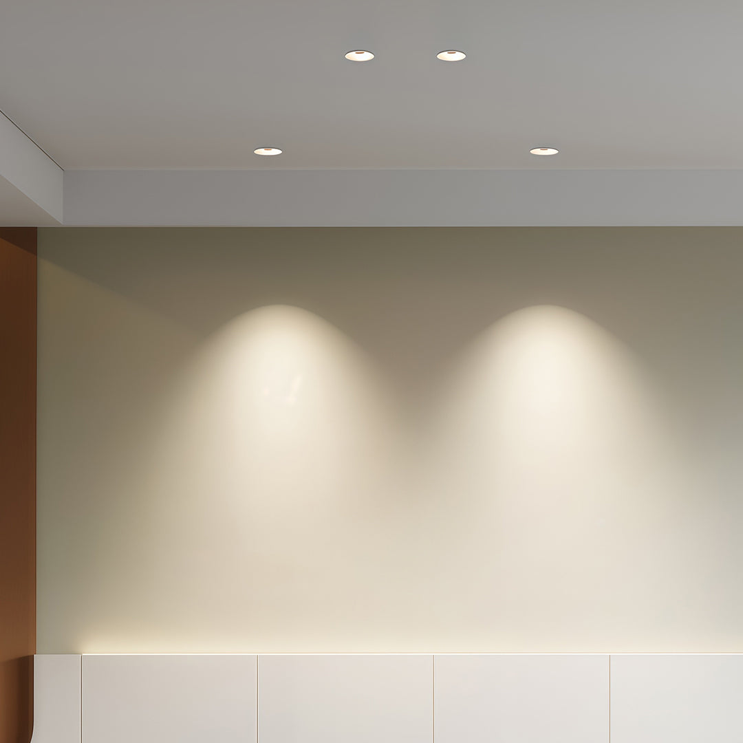 Row of flush mount spotlights brightening clean white walls in contemporary interior space
