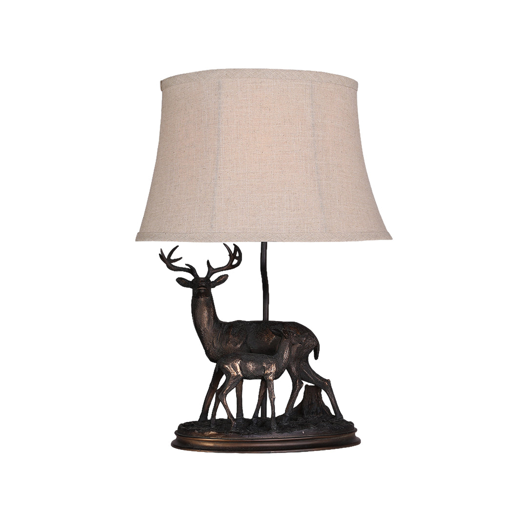 Rustic accent deer table lamp featuring a detailed bronze-tone stag and fawn sculpture base and a natural fabric shade.